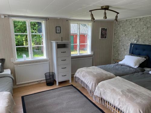TingstädeMartebo Bed & Breakfast的一间卧室设有两张床、一个梳妆台和窗户。