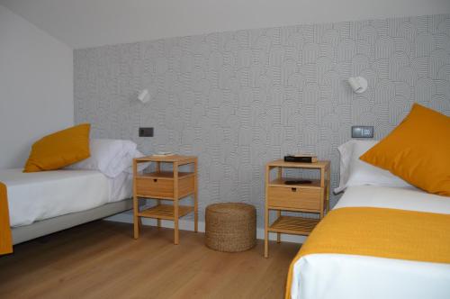 Santiago del CampoCasa Rural Casamanín的一间卧室设有两张床和两个床头柜