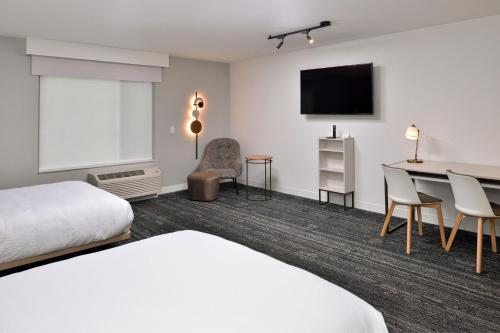 阿什维尔TownePlace Suites by Marriott Asheville Downtown的酒店客房配有一张床、一张书桌和一台电视。