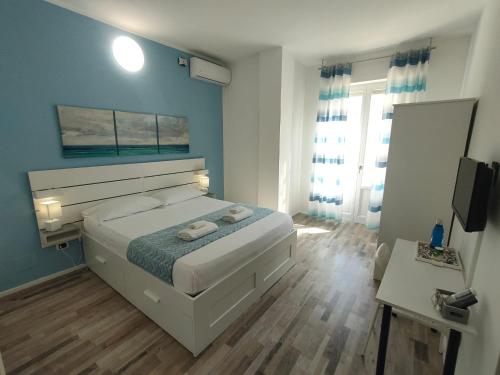卡利亚里Iris Rooms的卧室配有白色的床和蓝色的墙壁
