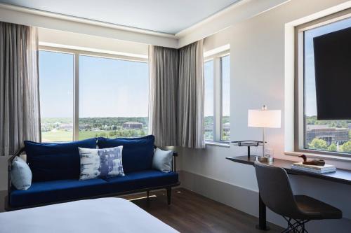 威斯特维尔威斯特维尔-北极星哥伦布万丽酒店的酒店客房设有蓝色的沙发、书桌和窗户。