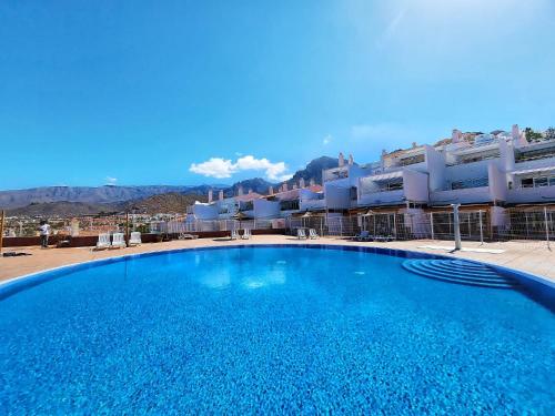 阿德耶Ocean View Villas Canarias的大楼前的大型蓝色游泳池