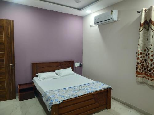 门格洛尔Manasvi的卧室配有白色墙壁上的床铺