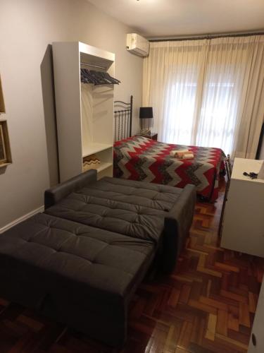 阿雷格里港Studioaconchegantepoa的一间卧室配有一张床和一张沙发