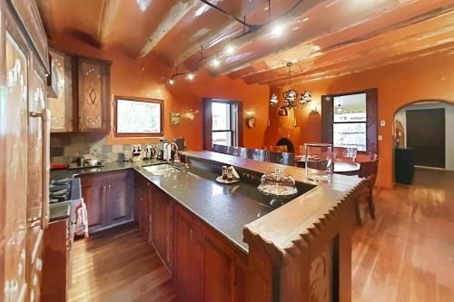 圣达菲Antigua Inn的大型厨房拥有橙色的墙壁和木地板