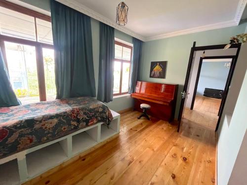西格纳吉Mishas Haus的一间卧室配有一张床、镜子和钢琴