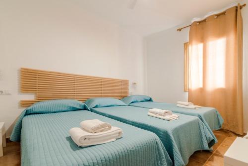 圣费兰-德瑟斯罗Apartamentos Mayans的卧室内的两张床和毛巾