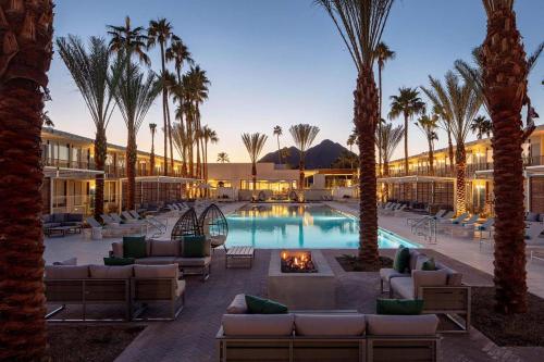 斯科茨Hotel Adeline, Scottsdale, a Tribute Portfolio Hotel的一个带棕榈树和沙发的游泳池的度假酒店