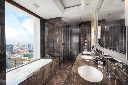 大阪大阪瑞吉酒店的一间带两个盥洗盆、浴缸和窗户的浴室