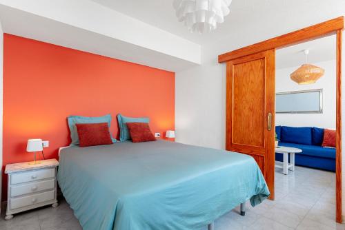 圣地亚哥港Panomaric Sea View - Sol Apartment的一间卧室配有蓝色的床和蓝色的沙发