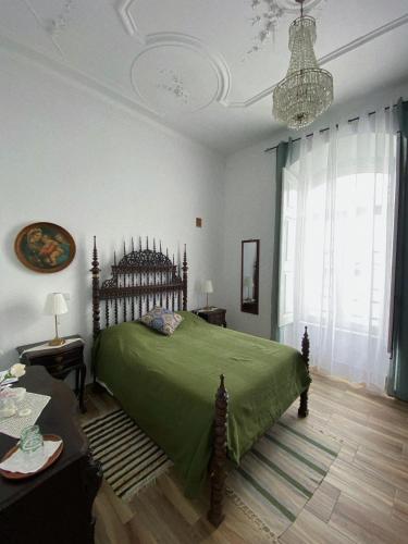 皮亚斯Pias Guesthouse的一间卧室配有一张绿色的床和吊灯。