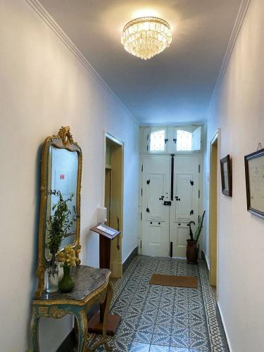 皮亚斯Pias Guesthouse的走廊上设有镜子和桌子,上面有西德西德西德