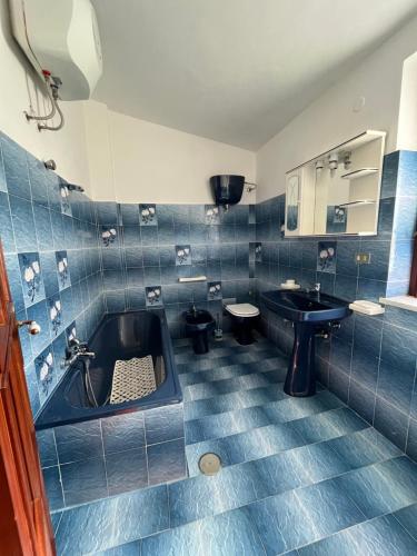 帕尔盖利亚Piccola Mansarda的蓝色瓷砖浴室设有水槽和浴缸