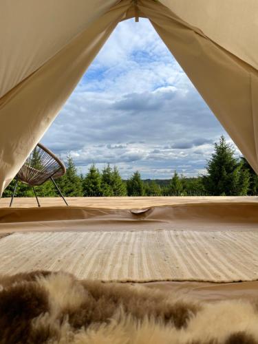 奥泰佩Restu Forrest Glamp的帐篷配有桌椅,享有景观