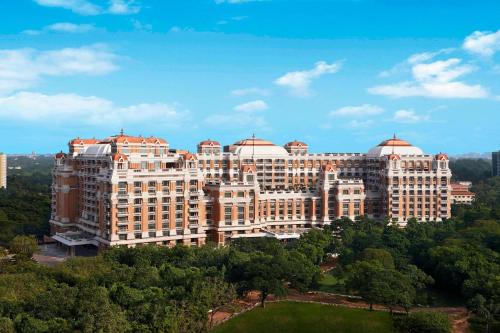 钦奈ITC Grand Chola, a Luxury Collection Hotel, Chennai的前面有树木的大建筑