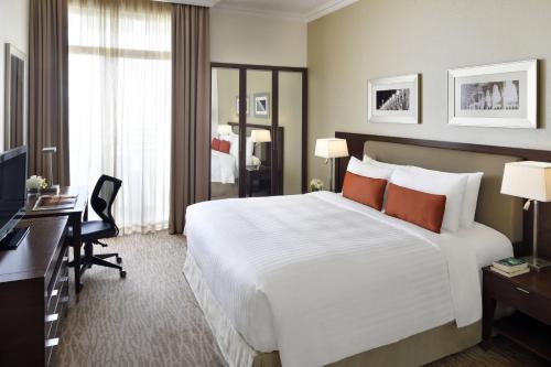 利雅德利雅得会议中心万豪行政公寓式酒店的酒店客房设有一张白色大床和一张书桌