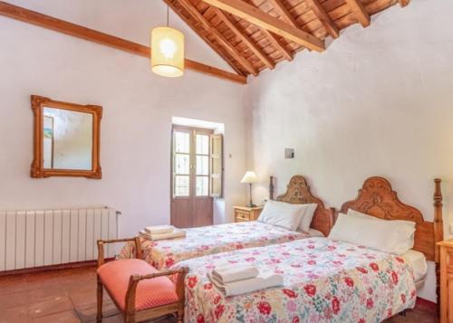 贝瑙汉Molino del Caracol的一间卧室配有两张床和一张桌子及椅子