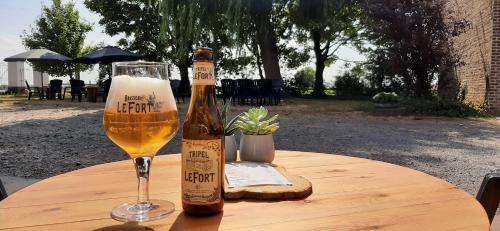 PoelkapelleVarlet Farm的一瓶啤酒和一张桌子上的一杯