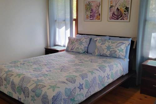 罗阿坦Casa Sueño Caribeño的一间卧室配有一张床、床罩和枕头