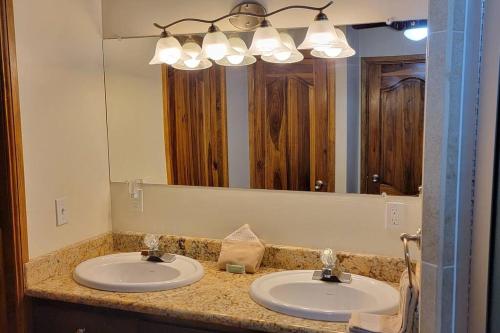 罗阿坦Casa Sueño Caribeño的一间带两个盥洗盆和大镜子的浴室