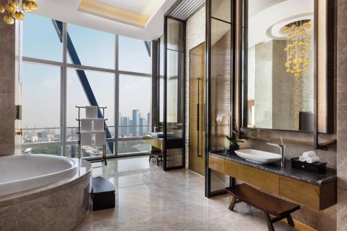 宝安深圳前海华侨城 JW 万豪酒店(宝安机场)的带浴缸和盥洗盆的浴室以及大窗户。