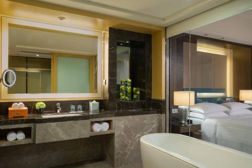 惠州惠州富力万丽酒店的一间带水槽、床和浴缸的浴室