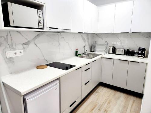 雅典Kipseli's Home的白色的厨房配有白色橱柜和水槽