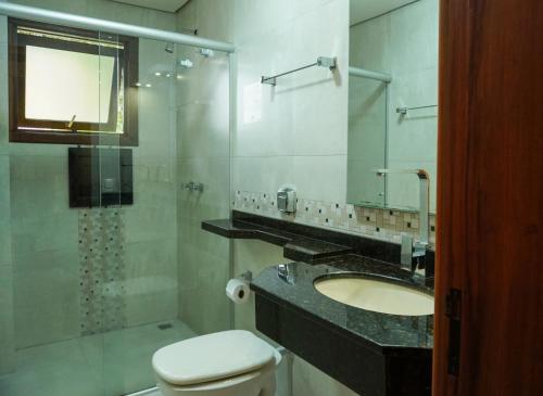 格拉玛多Pousada Das Papoulas的浴室配有卫生间、盥洗盆和淋浴。