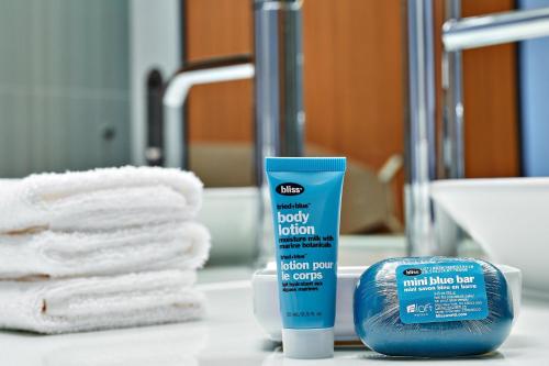 汉诺瓦BWI机场阿伦德尔米尔斯雅乐轩酒店的浴室柜台提供一瓶身体乳液和毛巾
