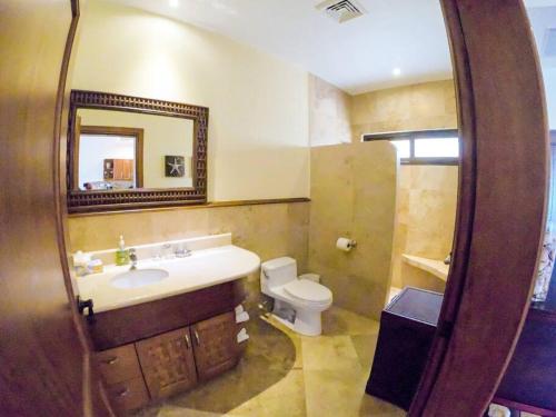罗阿坦Relax Enjoy Upscale Villa Pristine Bay的一间带水槽、卫生间和镜子的浴室