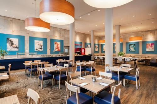 珀斯珀斯福朋喜来登的餐厅设有桌椅和蓝色的墙壁