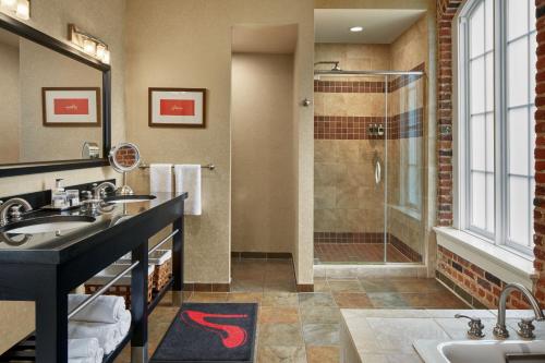 林奇堡Craddock Terry Hotel, Lynchburg, a Tribute Portfolio Hotel的一间带两个盥洗盆和淋浴的浴室