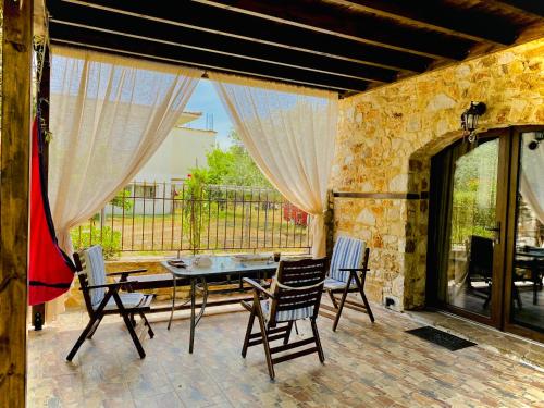 普里诺斯Villa Aggeliki的一个带桌椅的庭院和一个窗户。