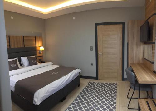 乌宗Kaya Life Resort的酒店客房配有一张床、一张书桌和一台电视。