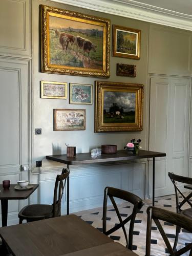 阿朗松Les Deux Marguerite的墙上有绘画,配有桌椅
