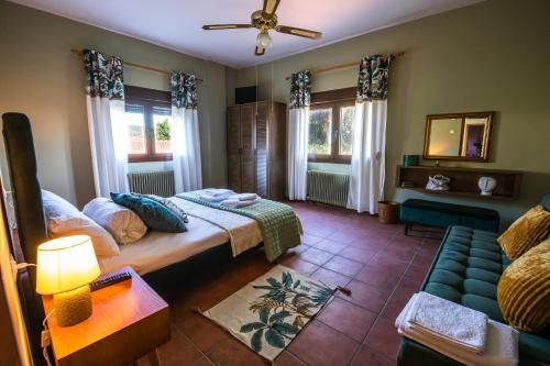 沃洛斯The Village House的一间卧室配有一张床、一张沙发和窗户。
