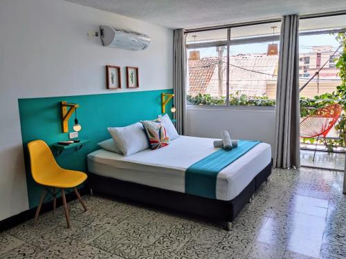 里奥阿查Bona Vida Hotel的卧室配有床、椅子和窗户。