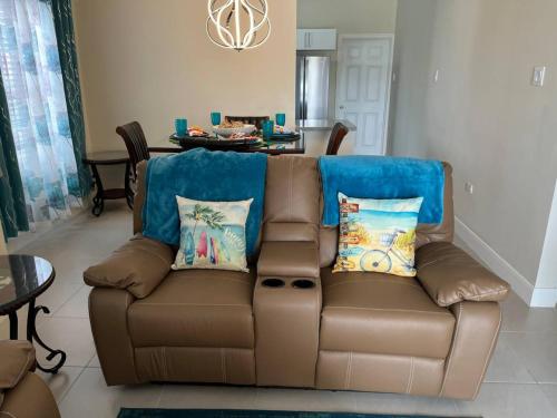 卢西Spacious apartments Crystal Waters的客厅配有带枕头的棕色沙发