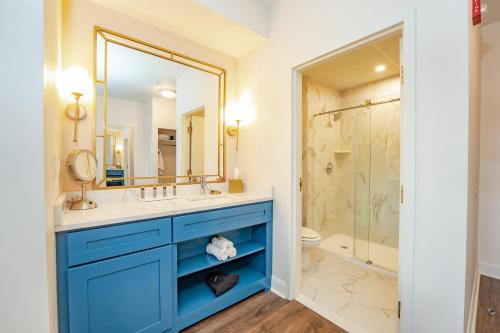 Egg Harbor CityChateau Renault的浴室配有蓝色梳妆台和淋浴。