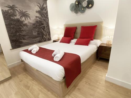 圣塞瓦斯蒂安Miramar Luxurious flat, 3 double rooms, free parking, terrace, completely new的一间卧室配有一张带红色枕头的大床