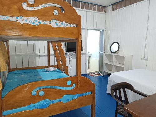 Puerto NariñoHospedaje El tigrillo的一间卧室配有一张双层床、一张桌子和一张床