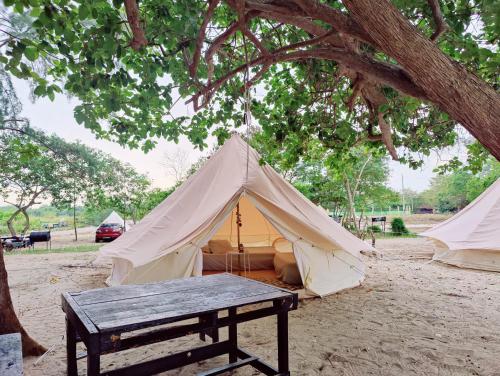 Kampong Tanjong Che LahomRustika Glamping的帐篷前设有野餐桌