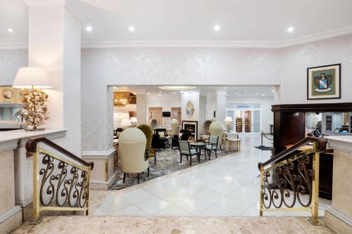 约翰内斯堡约翰内斯堡桑顿三角琴万豪Protea酒店的一间带椅子的客厅和一间餐厅