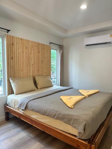 沙美岛Kala Krang Nueng的一间卧室配有一张大床和木制床头板