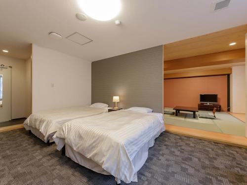 那须盐原市Itoen Hotel Shiobara的一间卧室配有一张大床和电视