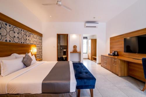 卡兰古特查尔斯顿度假村的一间卧室配有一张大床和一台平面电视
