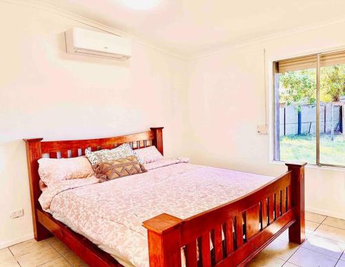艾利斯斯普林斯Grabber- Three bedroom charm in Alice Springs的一间卧室设有一张大木床和窗户