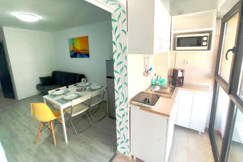 萨图恩Apartamente Design Residential Alfa Beta Vio Saturn的一间小厨房,内设桌子和水槽