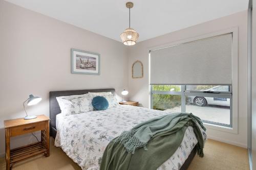 索雷尔港PLACE Port Sorell的卧室配有一张床,外面设有窗户,外面设有汽车