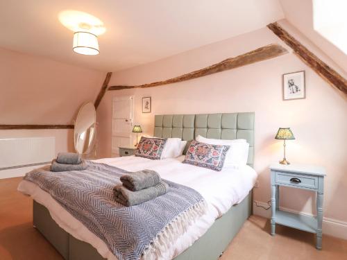 萨克斯曼德姆South Grange Cottage的一间卧室配有一张大床和毛巾